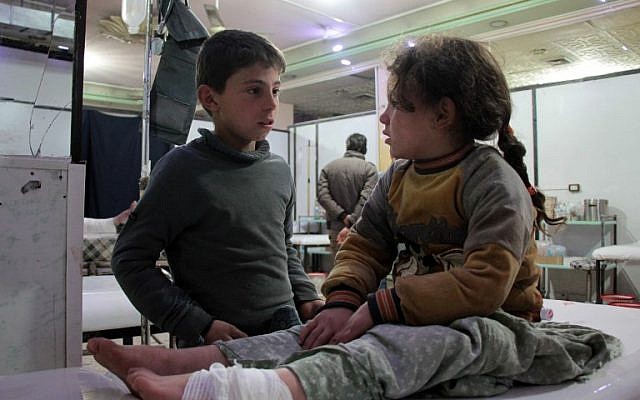A Syrian boy talks to an injured girl as she lies on an operating bed in an emergency room in the rebel-held town of Douma in Syria's eastern Ghouta region, on December 17, 2017, following the reported shelling of the area by government forces. (AFP PHOTO / Hamza Al-Ajweh) A Syrian boy talks to an injured girl as she lies on an operating bed in an emergency room in the rebel-held town of Douma in Syria's eastern Ghouta region, on December 17, 2017, following the reported shelling of the area by government forces. (AFP PHOTO / Hamza Al-Ajweh)