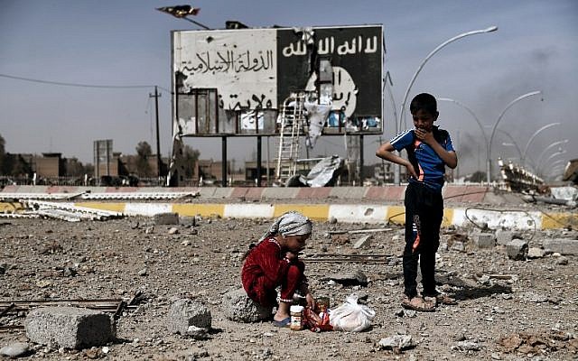 This file photo taken on March 12, 2017, shows Iraqi children sitting amidst the rubble of a street in Mosul's Nablus neighborhood in front of a billboard bearing the logo of the Islamic State terrir group. (AFP Photo/Aris Messinis) This file photo taken on March 12, 2017, shows Iraqi children sitting amidst the rubble of a street in Mosul's Nablus neighborhood in front of a billboard bearing the logo of the Islamic State terrir group. (AFP Photo/Aris Messinis)