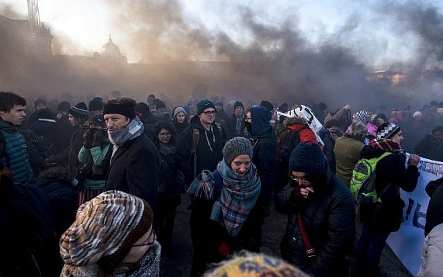 Demonstrators stand in the smoke rising from gas grenade during a protest against the new Austrian government near the presidential palace during the inauguration of the new Austrian government in Vienna, Austria, on December 18, 2017. ( AFP PHOTO / JOE KLAMAR)