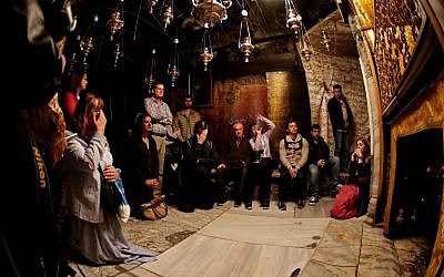 Christian worshipers pray near the 14-pointed silver star at the Grotto, believed to be the exact spot where Jesus Christ was born, in the Church of the Nativity in the West Bank city of Bethlehem, on December 21, 2017. (AFP PHOTO / THOMAS COEX)
