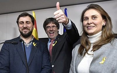 Axed Catalan president Carles Puigdemont, flanked by former Catalan Health minister Antoni Comin, left, and former Catalan Minister of Agriculture, Livestock, Fisheries and Food Meritxell Serret, reacts after the results of the regional elections in Catalonia  in Brussels on December 21, 2017. (AFP/ JOHN THYS)