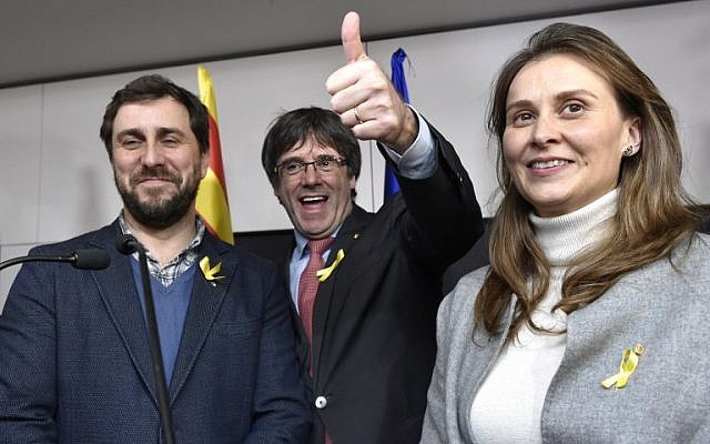 Axed Catalan president Carles Puigdemont, flanked by former Catalan Health minister Antoni Comin, left, and former Catalan Minister of Agriculture, Livestock, Fisheries and Food Meritxell Serret, reacts after the results of the regional elections in Catalonia  in Brussels on December 21, 2017. (AFP/ JOHN THYS)