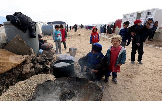Syrians, forced to leave their homes in the eastern cities of Deir Ezzor and Raqa by the war against the Islamic State (IS) group, are seen outside a tent at the Ain Issa camp on December 18, 2017. (AFP PHOTO / Delil Souleiman) Syrians, forced to leave their homes in the eastern cities of Deir Ezzor and Raqa by the war against the Islamic State (IS) group, are seen outside a tent at the Ain Issa camp on December 18, 2017. (AFP PHOTO / Delil Souleiman)
