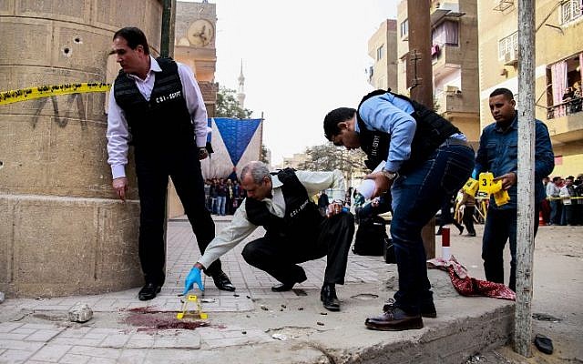 Egyptian security members and forensic police inspect the site of a gun attack outside a church south of the capital Cairo, on December 29, 2017. (AFP PHOTO / Samer ABDALLAH) Egyptian security members and forensic police inspect the site of a gun attack outside a church south of the capital Cairo, on December 29, 2017. (AFP PHOTO / Samer ABDALLAH)