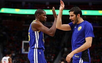 Kevin Durant #35 of the Golden State Warriors celebrates a second half basket with Omri Casspi #18 while playing the Detroit Pistons at Little Caesars Arena on December 8, 2017 in Detroit, Michigan. (Gregory Shamus/Getty Images/AFP)