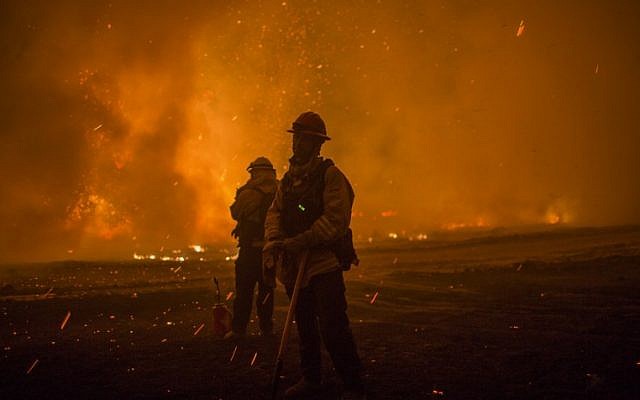 Embers fall on firefighters setting a backfire at night to make progress against the Thomas Fire before the winds return with the daylight near Lake Casitas on December 9, 2017 near Ojai, California. (David McNew/Getty Images/AFP) Embers fall on firefighters setting a backfire at night to make progress against the Thomas Fire before the winds return with the daylight near Lake Casitas on December 9, 2017 near Ojai, California. (David McNew/Getty Images/AFP)