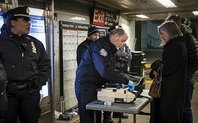 Members of the Transportation Security Administration and New York City Police Department check the bags of passengers as they enter the Times Square subway station during the evening rush hour, on December 11, 2017. (Drew Angerer/Getty Images/AFP)