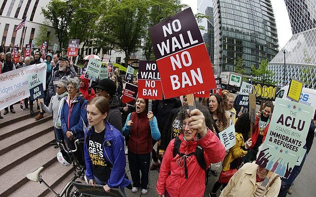 In this file photo from May 15, 2017, protesters wave signs and chant during a demonstration against US President Donald Trump's revised travel ban outside a federal courthouse in Seattle. (AP Photo/Ted S. Warren, File) In this file photo from May 15, 2017, protesters wave signs and chant during a demonstration against US President Donald Trump's revised travel ban outside a federal courthouse in Seattle. (AP Photo/Ted S. Warren, File)
