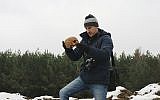 This photo from Dec. 5, 2017, shows an unidentified man holding human remains which had been removed from an old Jewish cemetery and dumped in huge mounds in Siemiatycze, Poland. (Aleksander Schwarz/The Union of Jewish Communities in Poland via AP)