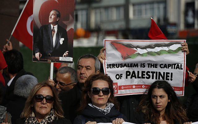 Protesters, holding Turkish and Palestinian flags and a placard of Mustafa Kemal Ataturk, the founder of modern Turkey, chant anti-U.S. slogans during a rally in Istanbul, Saturday, Dec. 9, 2017 against U.S. President Donald Trump's decision to recognise Jerusalem at the capital of Israel. (AP Photo/Lefteris Pitarakis)