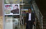 A Palestinian customer walks out of a shawarma restaurant with a poster of North Korean leader Jim Jong in Jebaliya refugee camp, Gaza Strip, December 14, 2017. (AP Photo/Adel Hana)
