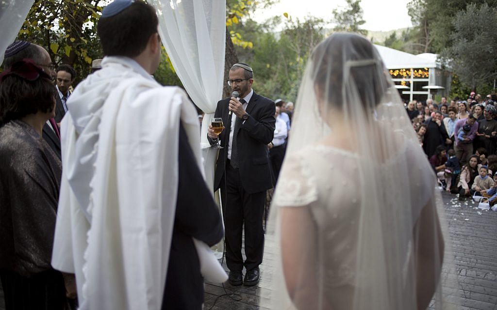 In this Thursday, December 14, 2017 photo, Rabbi Chuck Davidson holds a wedding service in Ein Hemed. A growing number of Israeli couples are defying the country’s Chief Rabbinate and marrying in unsanctioned weddings. (AP Photo/Ariel Schalit) In this Thursday, December 14, 2017 photo, Rabbi Chuck Davidson holds a wedding service in Ein Hemed. A growing number of Israeli couples are defying the country’s Chief Rabbinate and marrying in unsanctioned weddings. (AP Photo/Ariel Schalit)