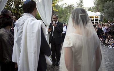 In this Thursday, December 14, 2017 photo, Rabbi Chuck Davidson holds a wedding service in Ein Hemed. A growing number of Israeli couples are defying the country’s Chief Rabbinate and marrying in unsanctioned weddings. (AP Photo/Ariel Schalit)