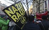 A demonstrator holds a poster 'Nazis out of the parliament' during a demonstration prior to the swearing-in ceremony of the new Austrian government led by a conservative and a nationalist party in Vienna, Austria, December 18, 2017. (Ronald Zak/AP)
