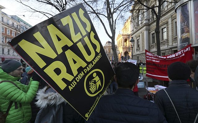 A demonstrator holds a poster 'Nazis out of the parliament' during a demonstration prior to the swearing-in ceremony of the new Austrian government led by a conservative and a nationalist party in Vienna, Austria, December 18, 2017. (Ronald Zak/AP) A demonstrator holds a poster 'Nazis out of the parliament' during a demonstration prior to the swearing-in ceremony of the new Austrian government led by a conservative and a nationalist party in Vienna, Austria, December 18, 2017. (Ronald Zak/AP)