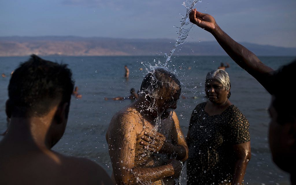 In this October 16, 2017 photo, tourists shower as they enjoy the Dead Sea near Kibbutz Kalya. (AP Photo/Oded Balilty)