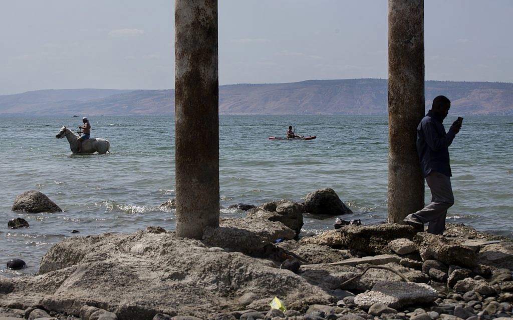 In this September 23, 2017 photo, people enjoy the Sea of Galilee near the northern Israeli Kibbutz of Ein Gev. (AP Photo/Oded Balilty)