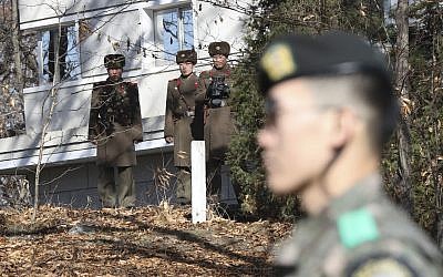 In this Nov. 27, 2017, file photo, North Korean soldiers look at the South side as a South Korean stands guard near the spot where a North Korean soldier crossed the border on Nov. 13 at the Panmunjom, in the Demilitarized Zone, South Korea. (AP Photo/Lee Jin-man, File)