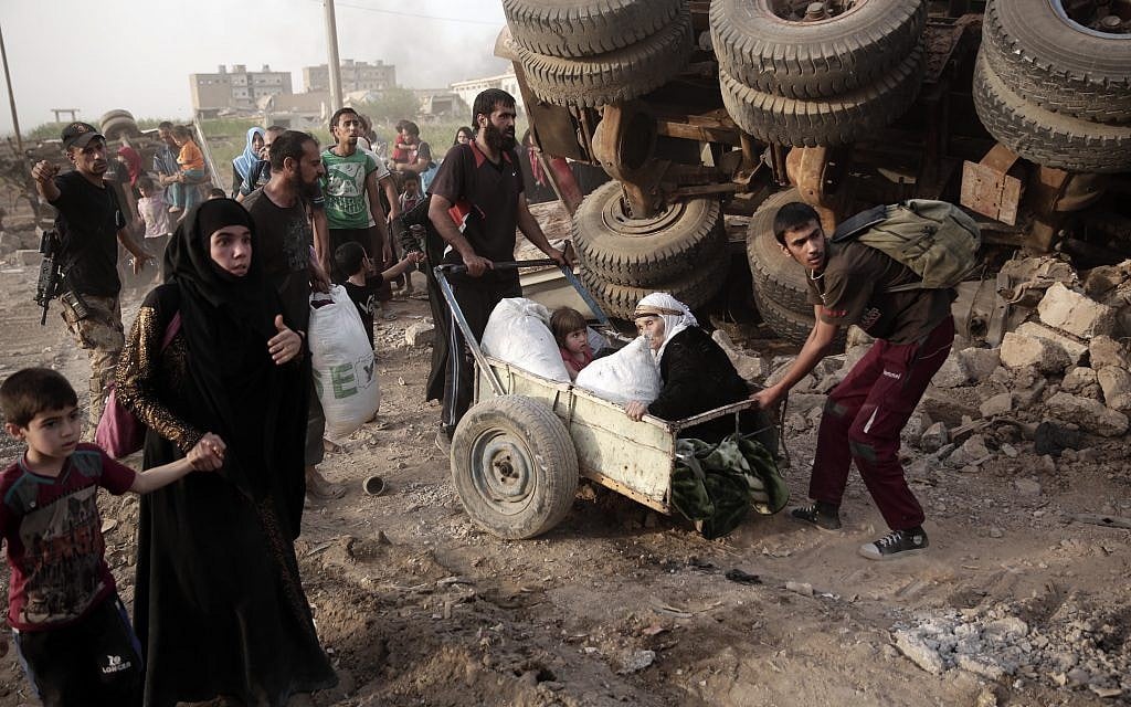 An elderly woman and a child are pulled on a cart as civilians flee heavy fighting between Islamic State militants and Iraqi special forces in western Mosul, Iraq on May 10, 2017. (AP Photo/Maya Alleruzzo)