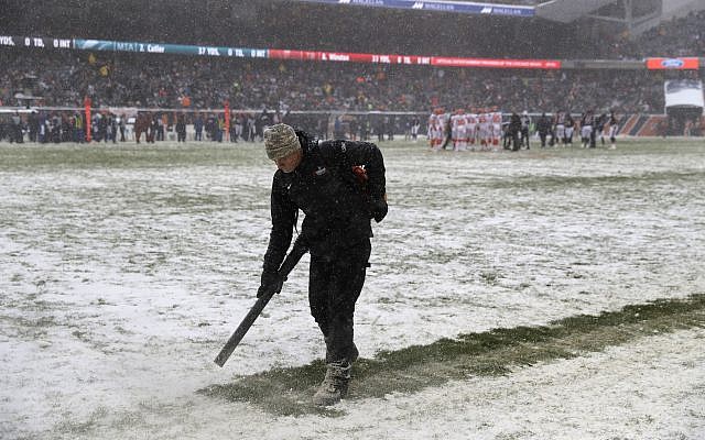 A worker clears snow from field lines at Soldier Field during an NFL football game between the Chicago Bears and Cleveland Browns in Chicago, December 24, 2017. (AP Photo/Charles Rex Arbogast) A worker clears snow from field lines at Soldier Field during an NFL football game between the Chicago Bears and Cleveland Browns in Chicago, December 24, 2017. (AP Photo/Charles Rex Arbogast)