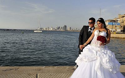A couple has their picture taken before their wedding at the Jaffa Port, as the Tel Aviv skyline is seen in the background. (Serge Attal/Flash90)