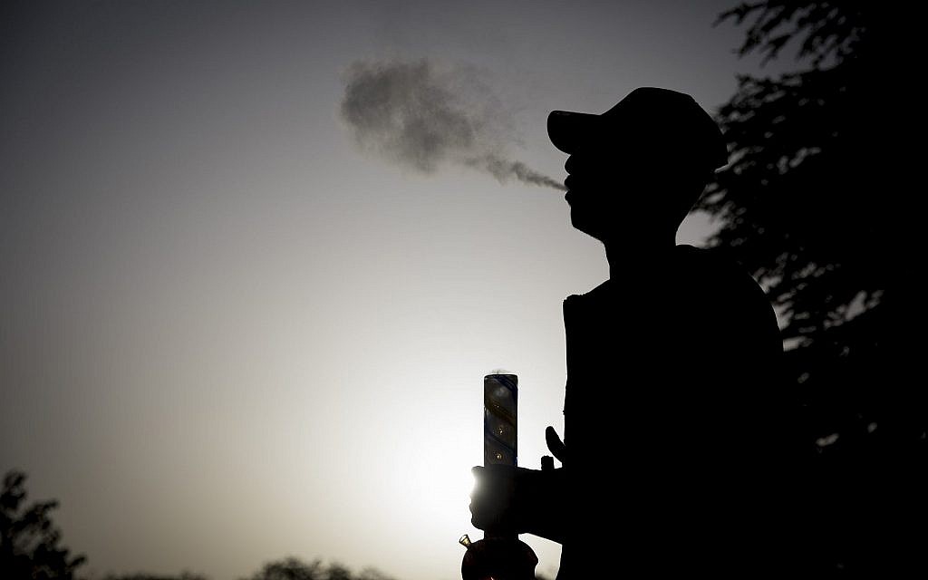 An Israeli is seen at the Rose Garden across from the Knesset during international marijuana smoking day in Jerusalem, on April 20, 2017. (Yonatan Sindel/Flash90) An Israeli is seen at the Rose Garden across from the Knesset during international marijuana smoking day in Jerusalem, on April 20, 2017. (Yonatan Sindel/Flash90)