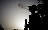 An Israeli is seen at the Rose Garden across from the Knesset during international marijuana smoking day in Jerusalem, on April 20, 2017. (Yonatan Sindel/Flash90)