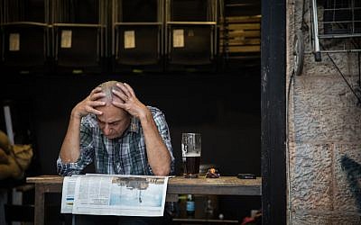 A man reads the newspaper at a cafe at the Mahane Yehuda Market in Jerusalem, on September 5, 2017. (Hadas Parush/Flash90)