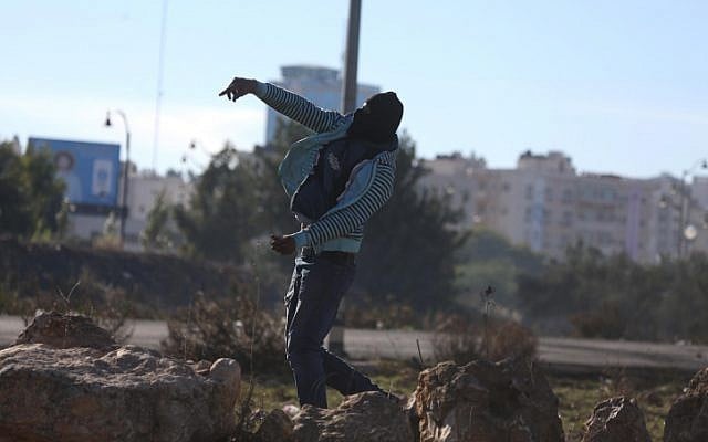 A Palestinian protester throws a rock at Israeli security forces during a violent protest near a checkpoint in the West Bank city of Ramallah on December 9, 2017. (Flash 90) A Palestinian protester throws a rock at Israeli security forces during a violent protest near a checkpoint in the West Bank city of Ramallah on December 9, 2017. (Flash 90)