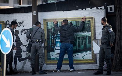 Israeli border police officers check a men near the Scene of a terror attack where a Palestinian man stabbed an Israeli man at the Central Bus Station in Jerusalem, on December 10, 2017. (Yonatan Sindel/Flash90)