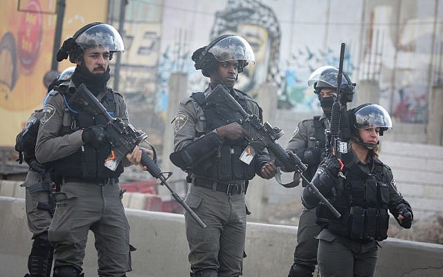 Israeli border police face Palestinian protesters at the Qalandiya checkpoint near the West Bank city of Ramallah on December 15, 2017, (Flash90) Israeli border police face Palestinian protesters at the Qalandiya checkpoint near the West Bank city of Ramallah on December 15, 2017, (Flash90)