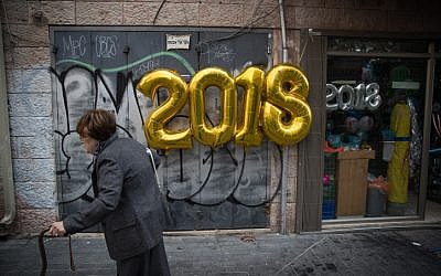 A woman walks past a New Year's balloon in central Jerusalem on December 15, 2017. (Yonatan Sindel/Flash90)