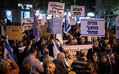 Israelis hold signs and shout slogans during a rally against corruption in government, at Zion Square in Jerusalem on December 23, 2017. (Hadas Parush/Flash90)
