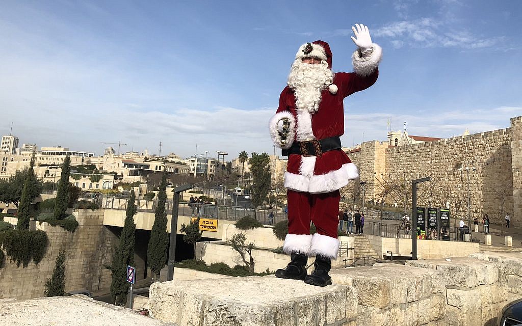 Jerusalem Santa, as portrayed by Issa Kassissieh, walking the ramparts of the Old City in Jerusalem, on December 21, 2017. (Jessica Steinberg/Times of Israel)
