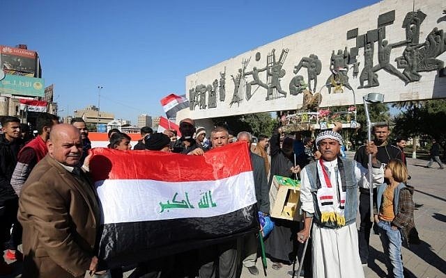 Iraqis wave the national flag at the Tahrir Square in the capital Baghdad on December 10, 2017, during a military parade to mark the end of a three-year war against the Islamic State group. (AFP PHOTO / AHMAD AL-RUBAYE) Iraqis wave the national flag at the Tahrir Square in the capital Baghdad on December 10, 2017, during a military parade to mark the end of a three-year war against the Islamic State group. (AFP PHOTO / AHMAD AL-RUBAYE)
