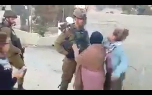 A Palestinian girl slaps an IDF officer in the face in an apparent attempt to get him to respond violently so the encounter could be filmed and shared online, during a protest in the West Bank village of Nabi Saleh on December 15, 2017. (Screen capture)