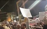 A man with a cardboard guillotine attends an anti-Netanyahu rally in Tel Aviv on December 23, 2017 (screen capture: 0404.co.il)