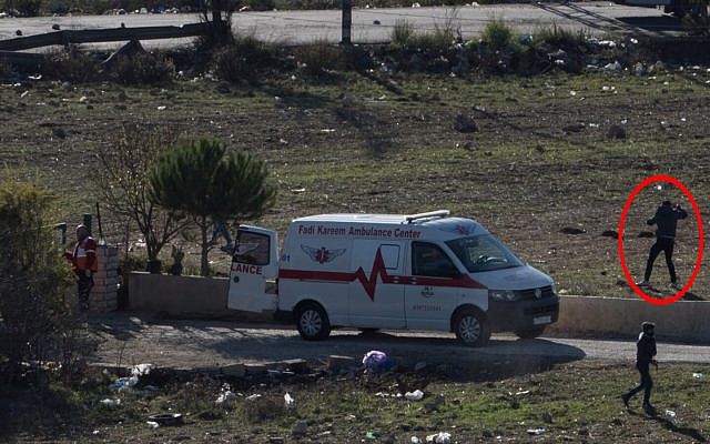 A Palestinian rock thrower apparently uses an ambulance as a shield during a violent demonstration in Ramallah on December 9, 2017. (Israel Defense Forces) A Palestinian rock thrower apparently uses an ambulance as a shield during a violent demonstration in Ramallah on December 9, 2017. (Israel Defense Forces)