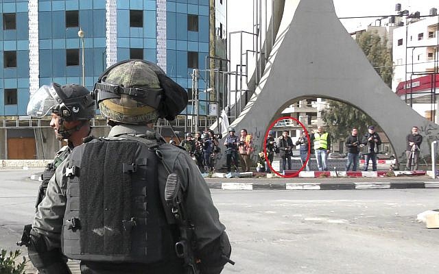 A Palestinian attacker, hiding among journalists, before he stabbed a Border Police officer in the West Bank city of Ramallah on December 15, 2017. (Israel Police) A Palestinian attacker, hiding among journalists, before he stabbed a Border Police officer in the West Bank city of Ramallah on December 15, 2017. (Israel Police)