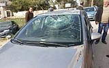 Palestinian residents of Burin stand next to a car whose windshield was shattered by Israeli settlers who attacked the village on December 28, 2017. (Courtesy: Yesh Din)