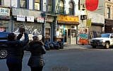 Pedestrians look on as workers remove a large penis mural from a building in New York City, December 2017 (YouTube screenshot)