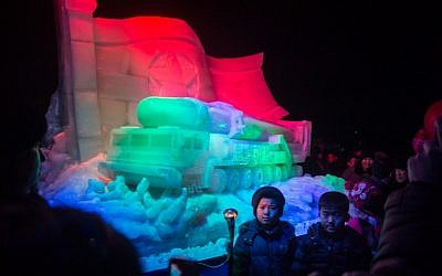 Children pose in front of an an ice sculpture depicting a Hwasong-15 intercontinental ballistic missile (ICBM) and self-propelled launcher, as people mark the new year at the Pyongyang Ice Sculpture Festival on Kim Il Sung Square in Pyongyang on December 31, 2017. (AFP PHOTO / KIM Won-Jin)