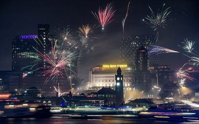Fireworks explode over the port in Hamburg, northern Germany, on January 1, 2018, to usher in the new year. (AFP PHOTO / dpa / Axel Heimken / Germany OUT)