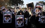 Pro-government demonstrators hold posters of Iran's supreme leader, Ayatollah Ali Khamenei (L) and Iran's founder of Islamic Republic, Ayatollah Ruhollah Khomeini during a march in Iran's holy city of Qom on January 3, 2018. (AFP PHOTO / Mohammad ALI MARIZAD)