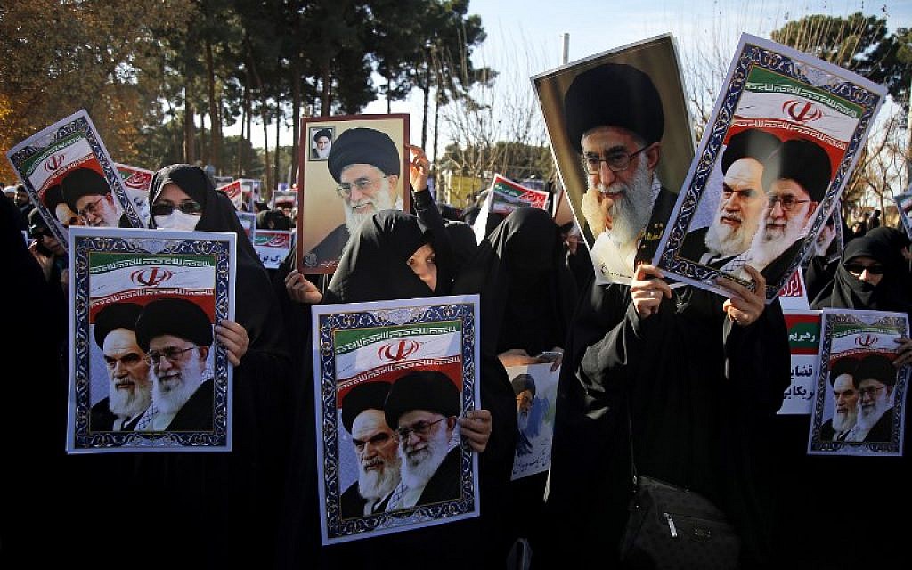 Pro-government demonstrators hold posters of Iran's supreme leader, Ayatollah Ali Khamenei, left, and Iran's founder of Islamic Republic, Ayatollah Ruhollah Khomeini during a march in Iran's holy city of Qom, 130 kilometres south of Tehran, January 3, 2018. (Mohammad ALI MARIZAD/AFP)