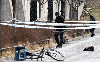 A policeman investigates a cordoned off area outside Varby Gard metro station south of Stockholm where one person died and one was injured in an explosion on January 7, 2018. (AFP PHOTO / TT News Agency / Henrik MONTGOMERY)