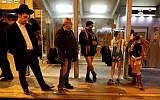 People taking part in the annual international "No Pants Subway Ride" day wait for the Jerusalem light train on January 7, 2018. (AFP PHOTO / AHMAD GHARABLI)
