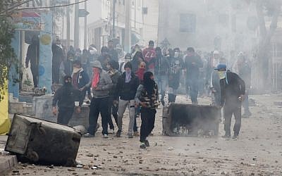 Following the funeral of a man who was killed the previous day in a demonstration over rising costs and government austerity, Tunisian protesters clash with security forces in the town of Tebourba on January 9, 2018. (Fethi Belaid/AFP)