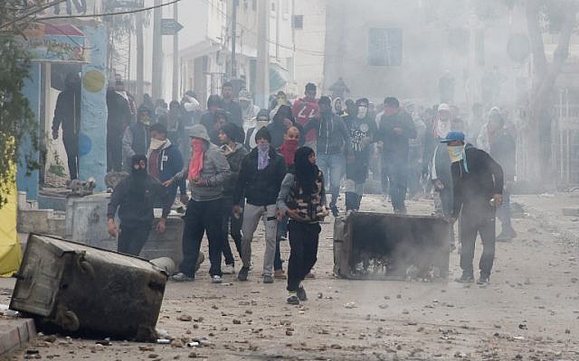 Following the funeral of a man who was killed the previous day in a demonstration over rising costs and government austerity, Tunisian protesters clash with security forces in the town of Tebourba on January 9, 2018. (Fethi Belaid/AFP) Following the funeral of a man who was killed the previous day in a demonstration over rising costs and government austerity, Tunisian protesters clash with security forces in the town of Tebourba on January 9, 2018. (Fethi Belaid/AFP)