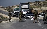 Illustrative: Israeli soldiers inspect cars at a checkpoint near the West Bank city of Nablus on January 10, 2018. (Jaafar/Ashtiyeh/AFP)